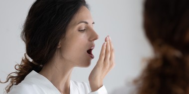 Vrouw ademt in haar hand