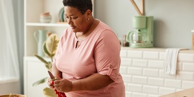 Vrouw met overgewicht maakt salade klaar