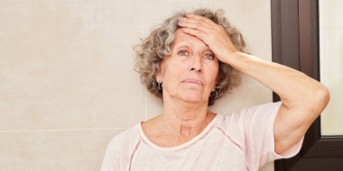 Vrouw met hand op haar voorhoofd