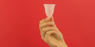 Hand die een menstruactiecup vasthoudt