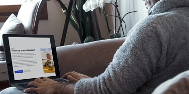 Man met laptop waarop de thuisarts-keuzehulp te zien is