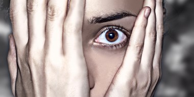 Close-up van persoon met handen voor het gezicht